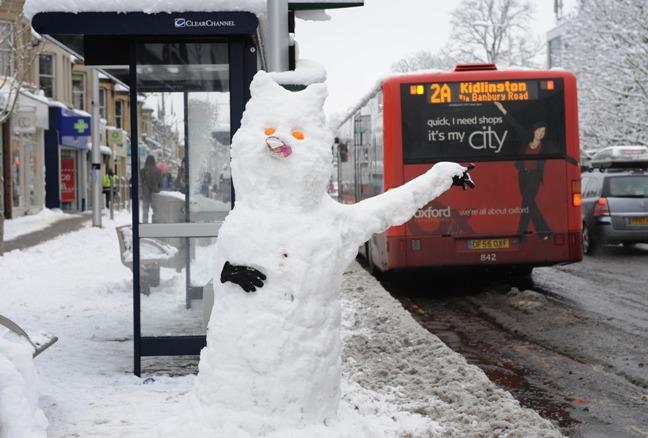 Snow chance: snowman waits in vain for a bus in icy Oxford