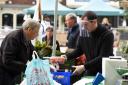 Pictured:  A stall holder with a face shield serves a customer at the fruit and veg stall...The Charter Market in Salisbury reopened today (Saturday), for food and other essential items, following it's closure due to the coronavirus pandemic...Various