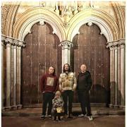 The new single by alternative pop band Love Is Enough. Pictured outside Salisbury Cathedral: From Left: Thor Porter, Cameron Walker and Ben Whatsley.  Front – Cameron’s rainbow son Atticus Walker