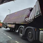 PHOTOS: Lorry stuck under railway bridge closing main road into city