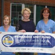 Jenny Hunt hands over a cheque to the Stars Appeal