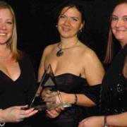 Jane Reid, of Spire FM, presents the Sales and Customer Service Award to Rachel Hayes and Jo Truckle from Less Bounce. DB3610P02