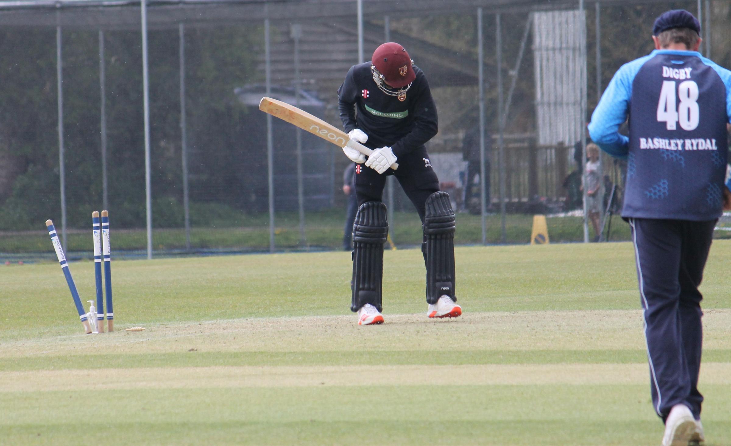 Will Harries is bowled by Brad Currie shouldering arms 