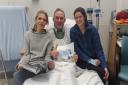 Chris Williams in hospital with his wife and daughter.