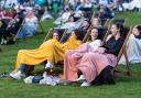Four girls sitting with blankets at an outdoor cinema. Credit: Adventure Cinema