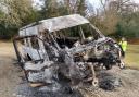 A stolen school minibus was dumped in a New Forest car park and set on fire.