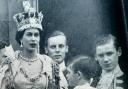 A young Prince Charles (now King Charles III) holds the hand of his mother Queen Elizabeth II at her Coronation