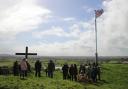 PICTURES: Residents brave the rain to carry crucifix up hill for Good Friday
