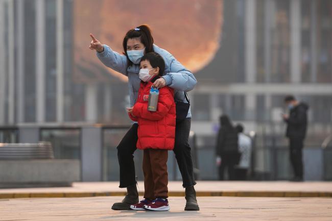 A woman and child wearing face masks in Beijing
