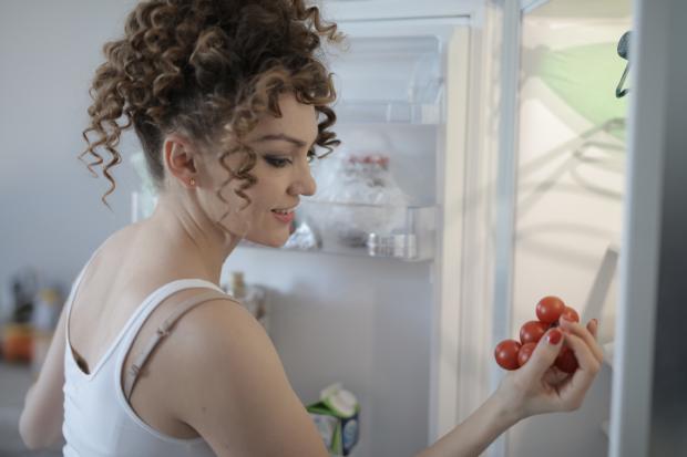 Salisbury Journal: A woman putting tomatoes in her fridge. Credit: Canva