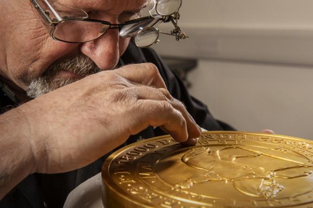 Salisbury Journal: Master craftsman Steve Dyer works on the 15 kilo gold coin by hand. Credit: The Royal Mint