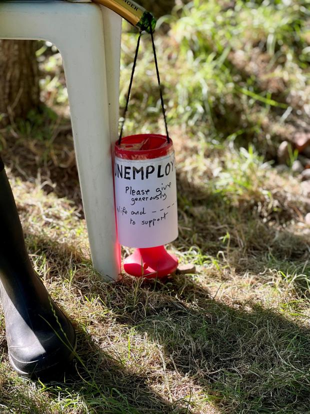Salisbury Journal: 'UNEMPLOYED. Please give generously. Wife and _ _ _ _ to support," is scrawled across the donation box dangling from the champagne bottle. Picture: Spencer Mulholland. 