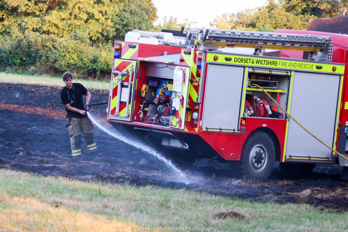 Fire crew dousing the smouldering field by Spencer Mulholland