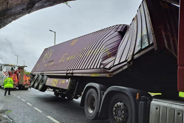 PHOTOS: Lorry stuck under railway bridge closing main road into city