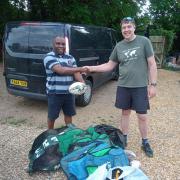 Andrew Byekwaso receiving donations from Jason Yarwood.