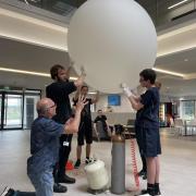 Pupils filled the balloon with helium, weighed it, then tied it up ready for launch.