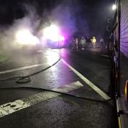 Drivers on looked in shock at the sight of a burnt-out car covered in police tape on the side of the road this morning.