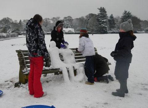 Some children in Woodgreen Common making a snowy sculpture of a couple. Taken by Dot Wagg.