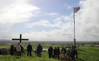 PICTURES: Residents brave the rain to carry crucifix up hill for Good Friday